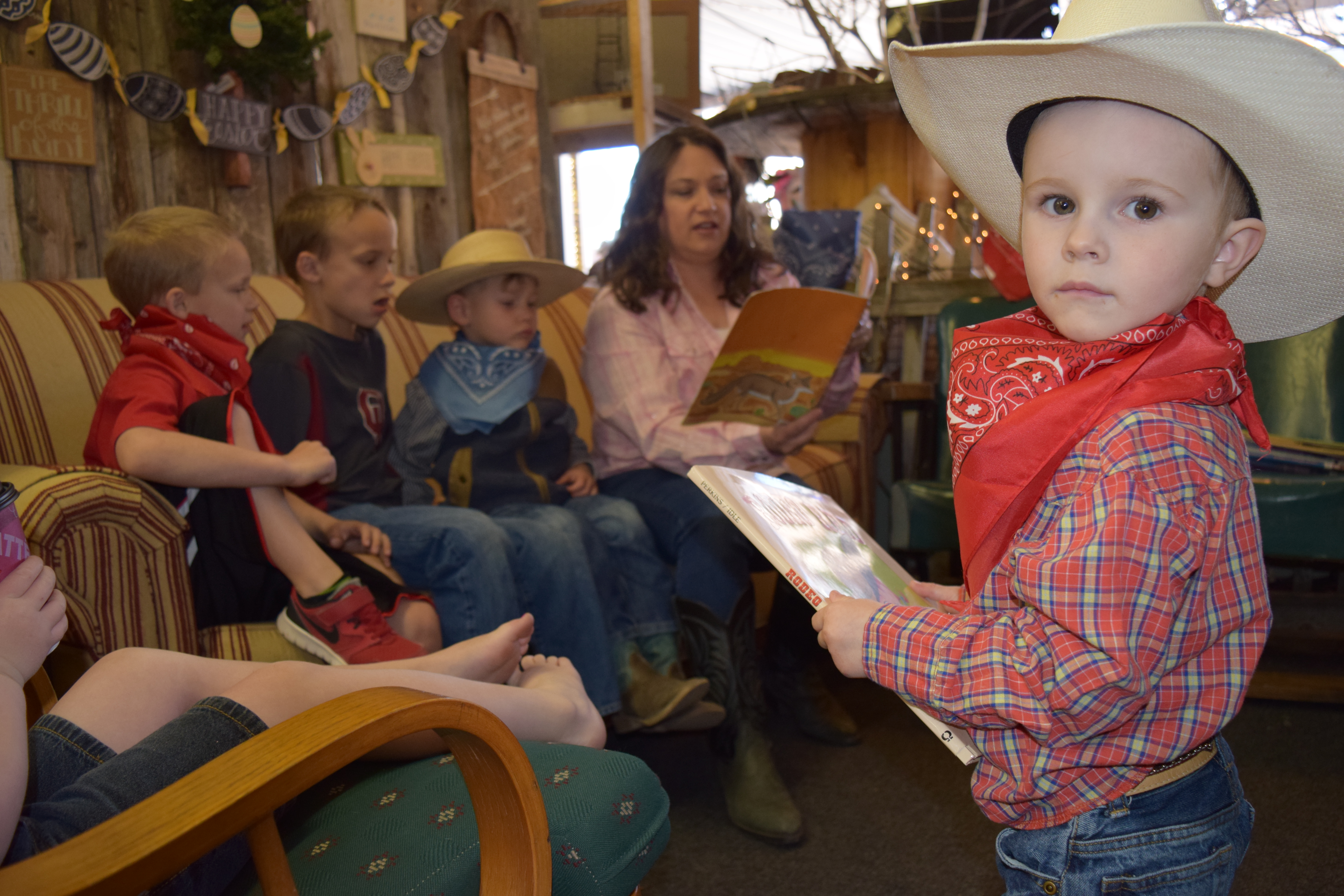 Kids dressed in Western wear listen to stories being read by volunteers at the Spring Roundup for Read & Romp in 2016.