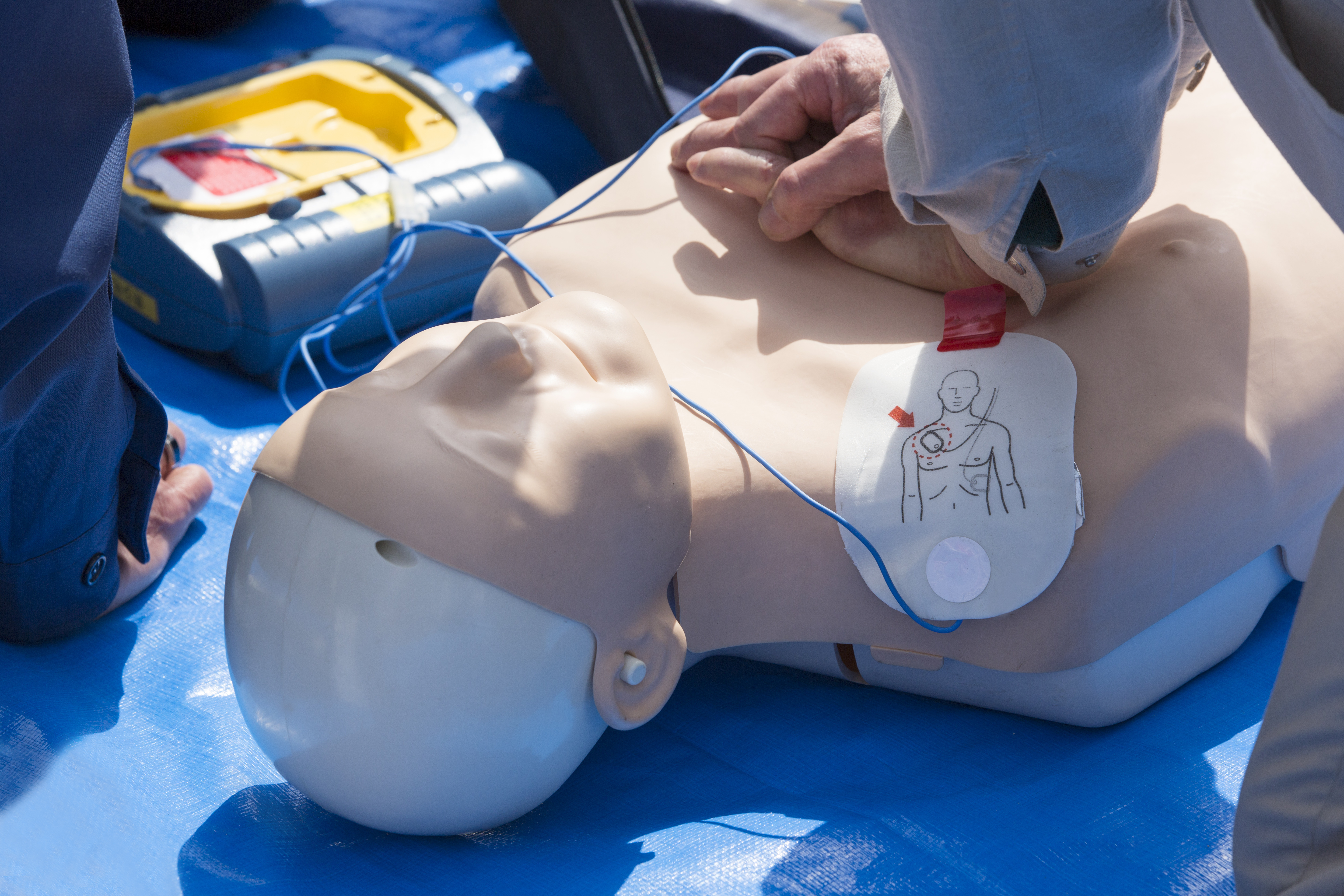 Hands placed on AED dummy